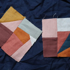 Color patchwork pieces in various colors sewn together on a dark blue fabric background