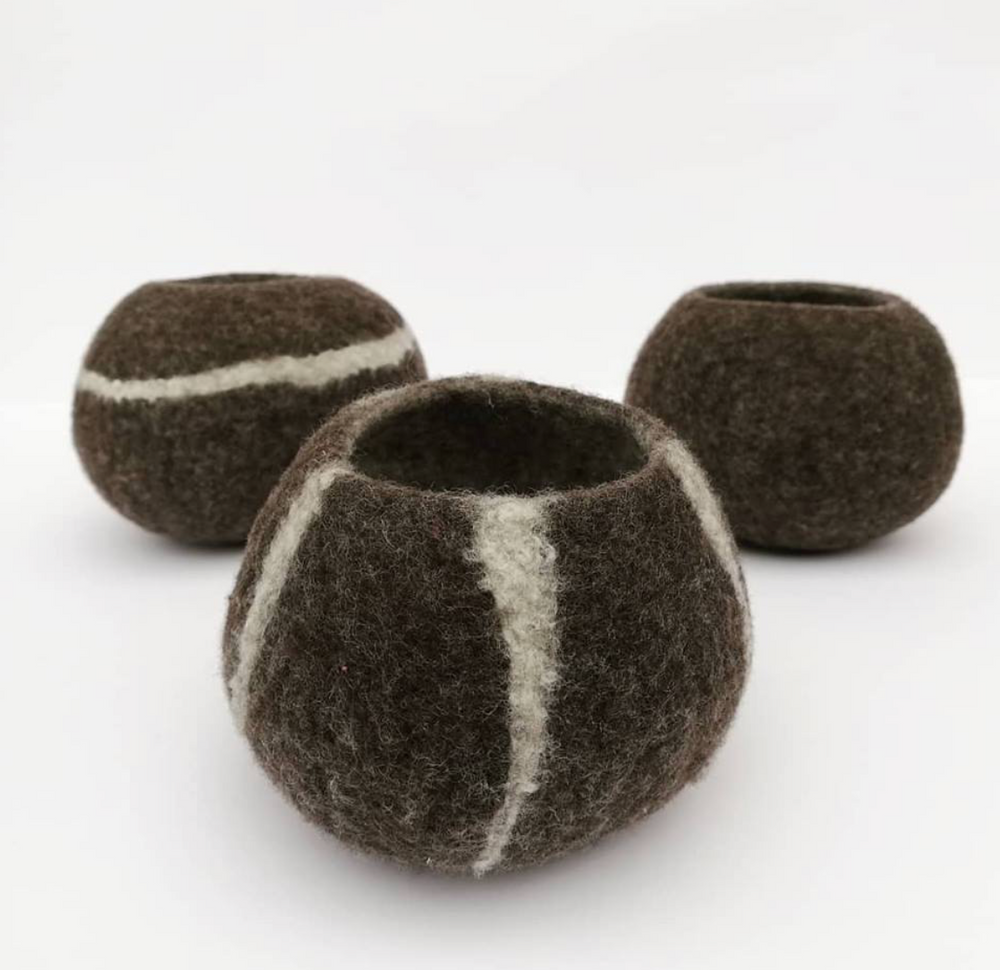 Three brown felted bowls with white stripes on a white background