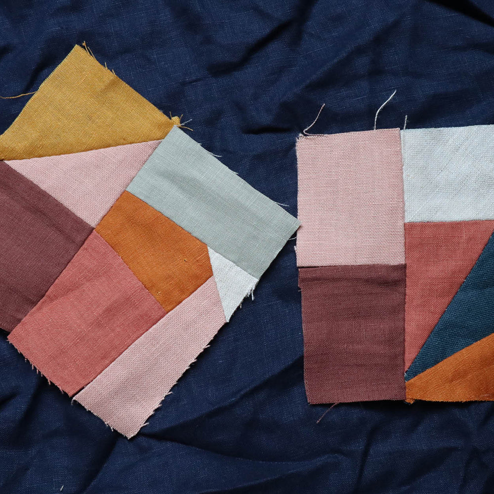 Color patchwork pieces in various colors sewn together on a dark blue fabric background